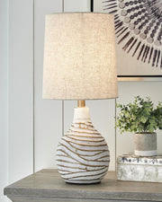 Aleela table lamp by Ashley Furniture with a sleek design, featuring a textured base and a neutral fabric lampshade.