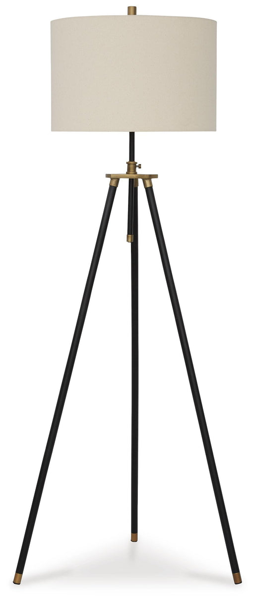 Ashley Furniture Cashner floor lamp with a sleek metal base and fabric shade, standing tall in a modern living room setting.