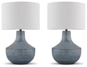 Set of two Ashley Furniture Schylarmont table lamps with beige fabric shades and carved base designs on a wooden surface.