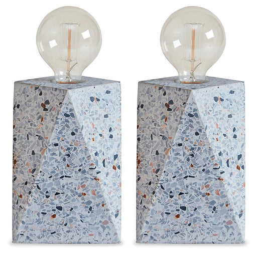 Maywick table lamp set by Ashley Furniture featuring two modern lamps with sleek bases and fabric shades on a wooden surface.