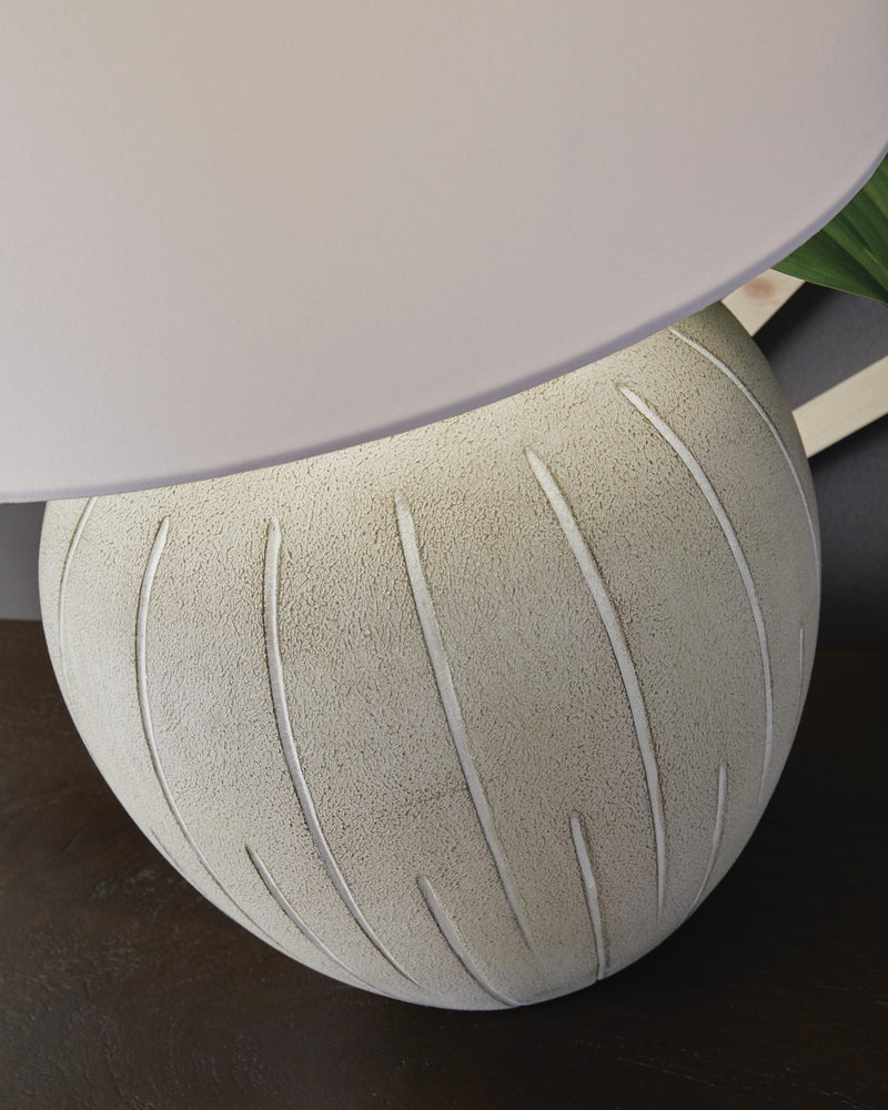 Ashley Furniture Calbert Table Lamp with a sleek ceramic base and fabric lampshade, ideal for modern living room decor.