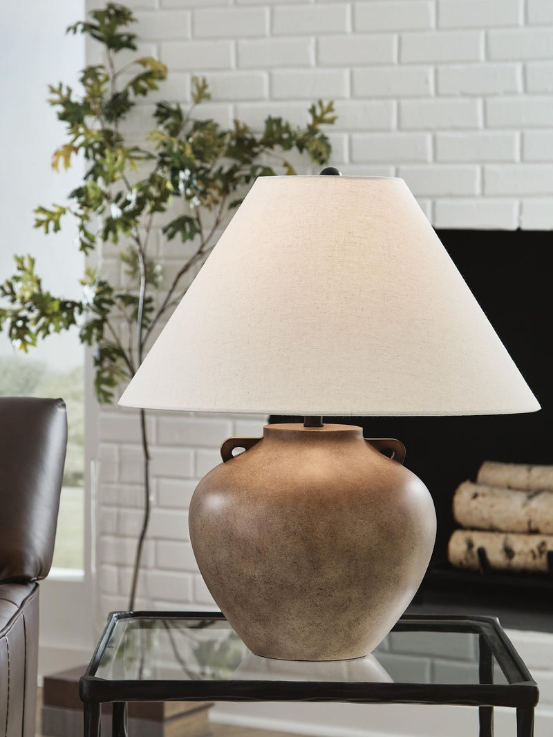 Ashley Furniture Ferrilby table lamp featuring a sleek design with a fabric shade and decorative base on a wooden table.