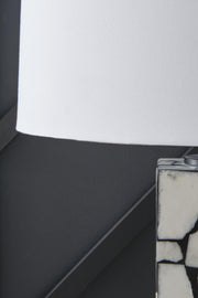 Close-up of the shade detail on the Macaria Table Lamp by Ashley Furniture, showcasing its elegant fabric design and warm lighting.