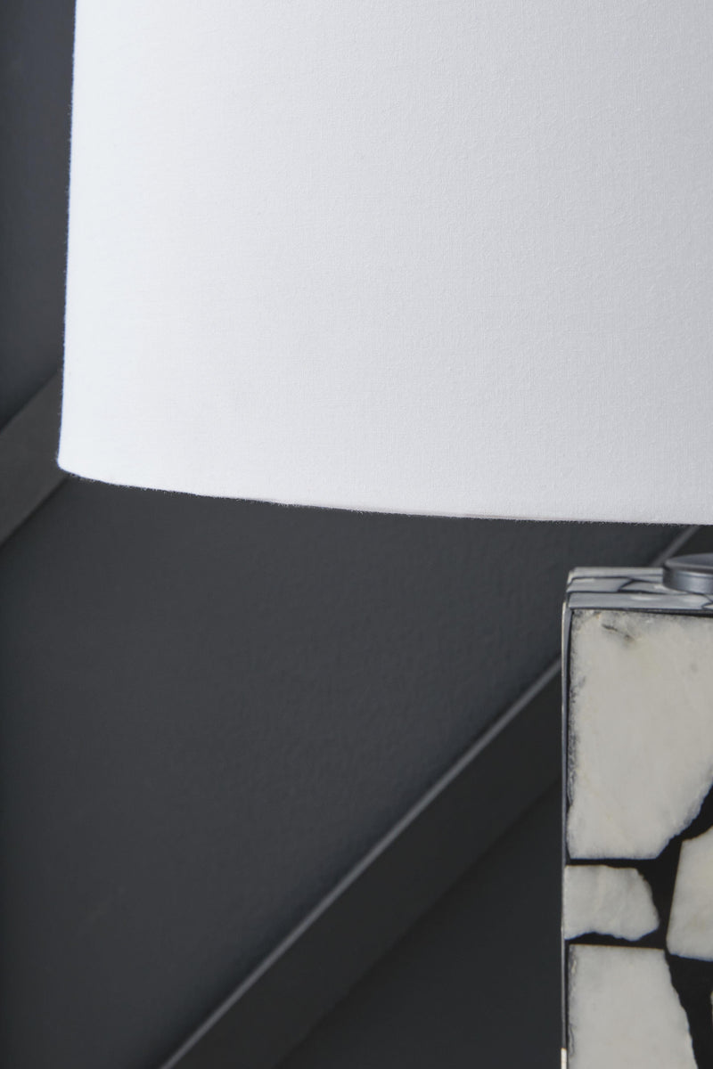 Close-up of the shade detail on the Macaria Table Lamp by Ashley Furniture, showcasing its elegant fabric design and warm lighting.