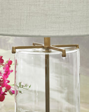 Ashley Furniture Gizeh Table Lamp with textured base and fabric shade, placed on a wooden side table in a cozy living room setting.