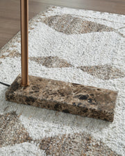 Close-up of Ashley Furniture Yafe Floor Lamp base showing sleek metal finish and modern design detail.