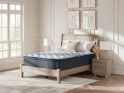 Ashley Furniture Plush Luxe 2.0 innerspring mattress with plush comfort and supportive coils, shown in a neatly made bed.