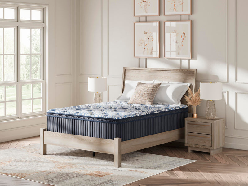 Ashley Furniture Plush Luxe 2.0 innerspring mattress with plush comfort and supportive coils, shown in a neatly made bed.