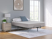 Ashley Furniture Terra Sleep Firm hybrid mattress with a plush fabric cover, shown on a bed frame in a modern bedroom setting.