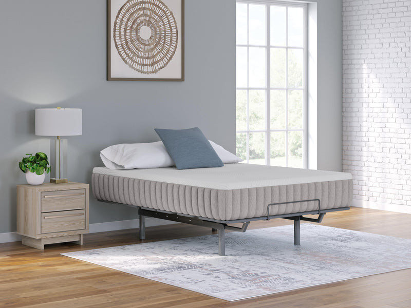 Ashley Furniture Terra Sleep Firm hybrid mattress with a plush fabric cover, shown on a bed frame in a modern bedroom setting.