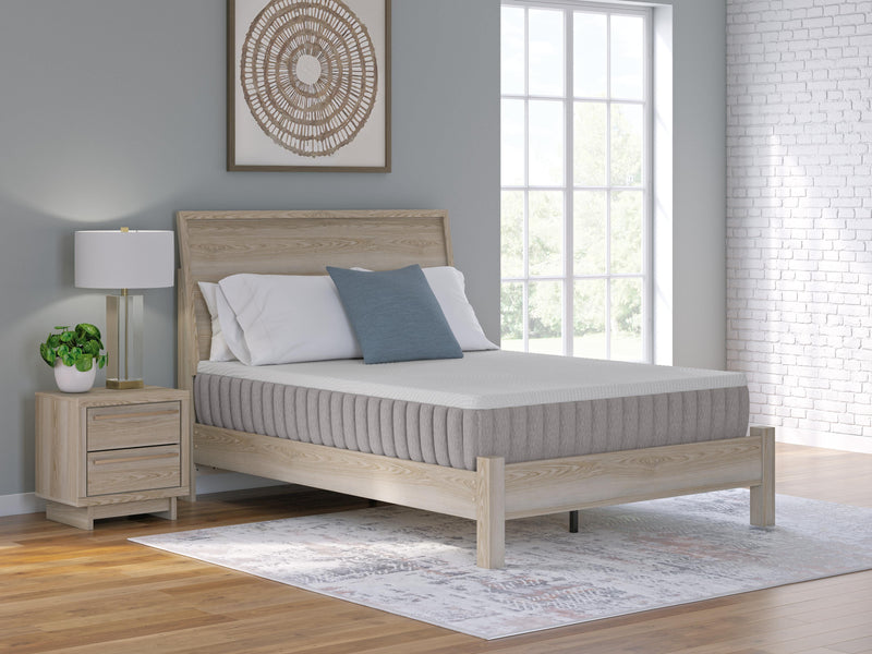 Ashley Furniture Terra Sleep Firm Hybrid Mattress showing a neatly made bed with white bedding and a supportive, firm mattress surface.