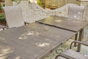 Outdoor dining table by Ashley Furniture featuring a sturdy wooden design, ideal for beach-front outdoor dining spaces.