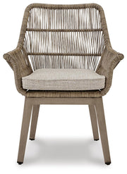 Set of two Ashley Furniture outdoor beach front arm chairs with cushions, featuring woven rattan design and sturdy metal frames.