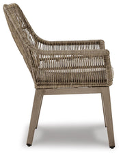 Set of two Ashley Furniture outdoor dining arm chairs with cushions, beach front style, featuring woven rattan design and metal frames.
