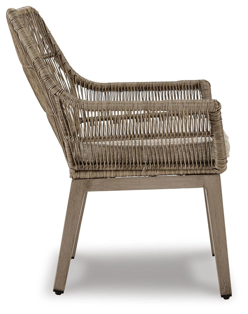 Set of two Ashley Furniture outdoor dining arm chairs with cushions, beach front style, featuring woven rattan design and metal frames.