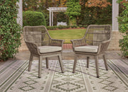 Set of two Ashley Furniture outdoor dining beach front arm chairs with cushions, perfect for relaxing by the water.