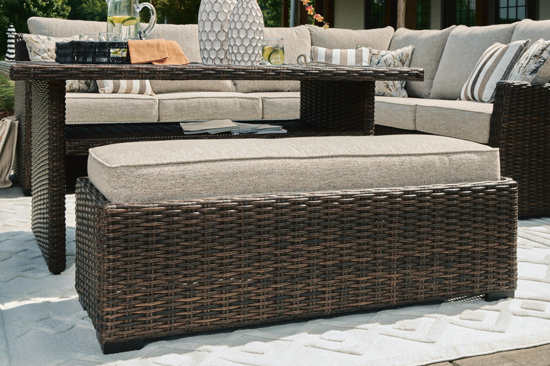 Ashley Furniture outdoor sectional with cushioned bench, featuring three connected seating pieces and detailed fabric upholstery.
