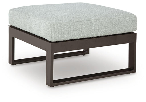 Ashley Furniture Beachloft outdoor ottoman with cushion, showing angled view of woven rattan design and comfortable padded seat.