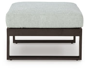 Ashley Furniture Beachloft outdoor sectional with beige cushions and wicker frame, shown from a front head-on perspective.