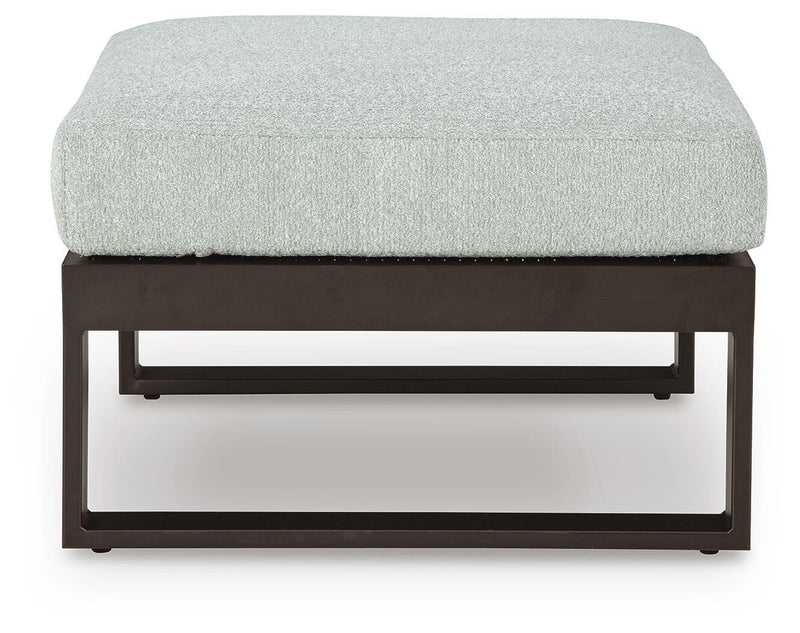 Ashley Furniture Beachloft outdoor sectional with beige cushions and wicker frame, shown from a front head-on perspective.