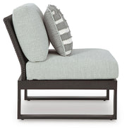 Ashley Furniture Beachloft outdoor sectional with beige cushions and woven rattan frame, designed for patio relaxation.