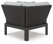 Ashley Furniture Beachloft outdoor sectional with beige cushions and weather-resistant wicker frame, arranged for lounging in the backyard.