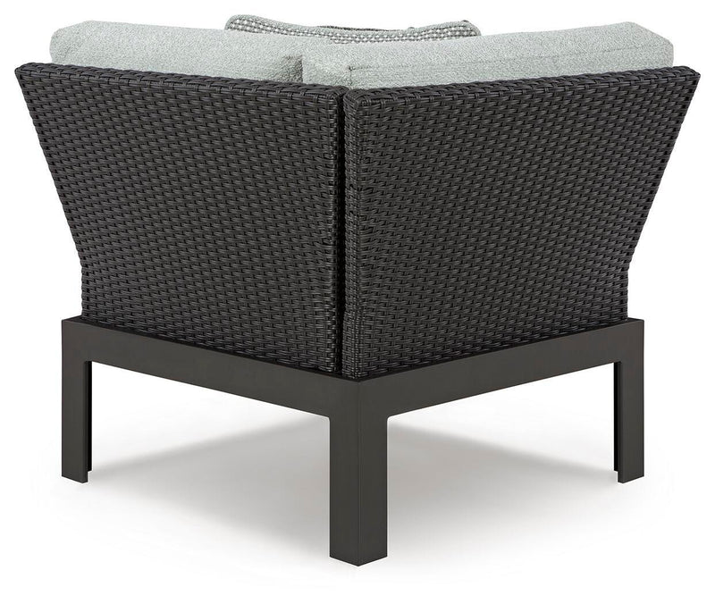 Ashley Furniture Beachloft outdoor sectional with beige cushions and weather-resistant wicker frame, arranged for lounging in the backyard.