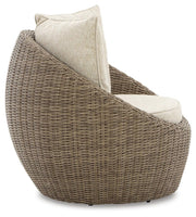 Two Ashley Furniture Danson swivel outdoor lounge chairs with cushions, shown side view in a modern outdoor setting.