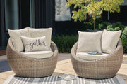Pair of Ashley Furniture Danson swivel outdoor lounge chairs with cushions, featuring modern design and comfortable seating.