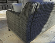 Outdoor loveseat with cushion from Ashley Furniture, featuring a stylish design perfect for outdoor seating and relaxation.