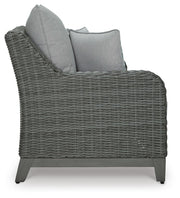 Outdoor loveseat by Ashley Furniture with cushioned seats and side table, designed for cozy outdoor relaxation.