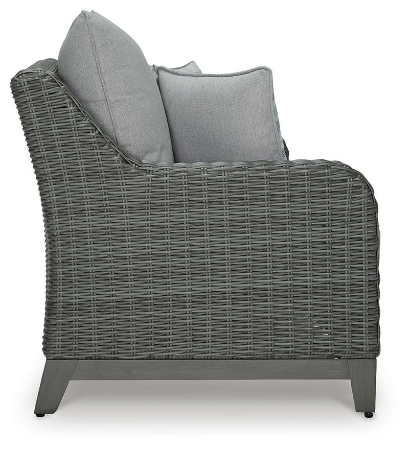 Outdoor loveseat by Ashley Furniture with cushioned seats and side table, designed for cozy outdoor relaxation.