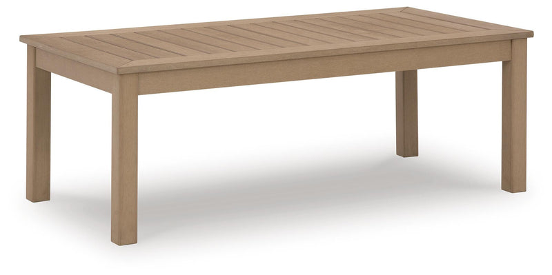 Outdoor cocktail table from Hallow Creek collection by Ashley Furniture, showing a stylish wooden surface and sturdy legs.