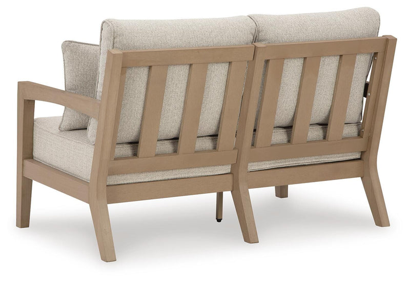 Ashley Furniture Hallow Creek outdoor loveseat with cushion, showing the back view and comfortable seating design.
