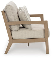 Ashley Furniture Hallow Creek outdoor loveseat with a cushion, featuring a sturdy frame and comfortable seating for outdoor relaxing.