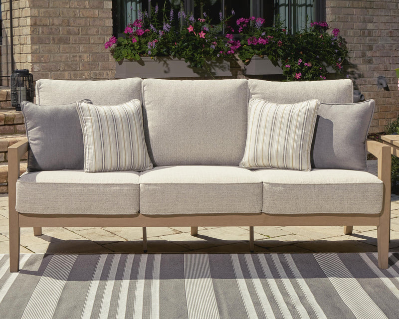Ashley Furniture Hallow Creek outdoor sofa with cushion, showing a stylish patio seating arrangement with plush cushions.