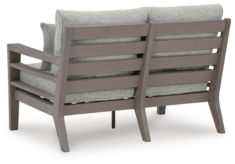 Ashley Furniture hillside barn outdoor loveseat with cushion, featuring a cozy seating area and rustic design for outdoor relaxation.