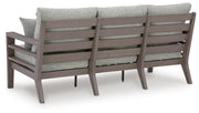 Ashley Furniture Hillside Barn outdoor sofa with cushions, showing the back view of the patio seating set.