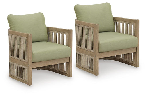 Two Ashley Furniture Serena Shores outdoor lounge chairs with woven frames and plush cushions, ideal for patio relaxation.