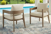 Outdoor dining set by Ashley Furniture featuring a glass-top table and six cushioned chairs in a serene bay setting.