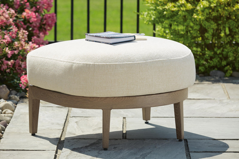 Outdoor Serene Bay Ottoman with cushion by Ashley Furniture, featuring a woven design and plush seating for outdoor relaxation.