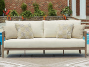 Ashley Furniture Serene Bay outdoor sofa with cushions, stylish outdoor seating with plush cushions on a modern patio setting.