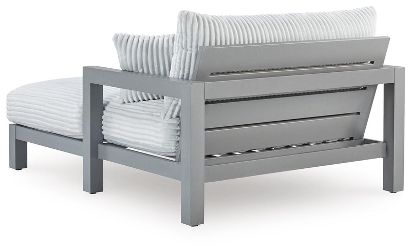 Hurley Park outdoor chaise lounge with cushion by Ashley Furniture, featuring a sleek design and comfortable seating for outdoor relaxation.
