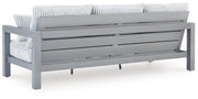 Ashley Furniture Hurley Park outdoor sofa with cushions, featuring a sturdy wooden frame and comfortable seating for outdoor spaces.