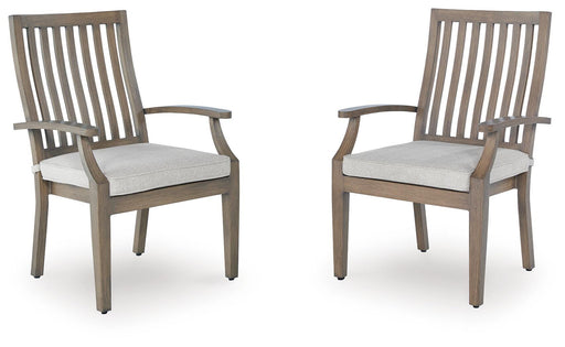Set of two Ashley Furniture Rainier Ranch outdoor arm chairs with cushions, featuring wooden frames and woven seats.