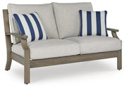 Outdoor loveseat with cushions by Ashley Furniture, featuring a sturdy frame and comfortable seating for outdoor relaxation.
