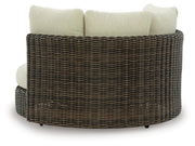 Kimora outdoor swivel lounge chair with cushion by Ashley Furniture, shown from the back with black metal frame and beige cushion.