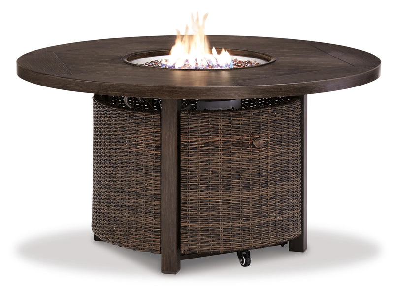 Ashley Furniture Paradise Trail outdoor table set with lounge chairs and fire pit table, shown from a side angle on a patio.