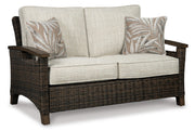 Outdoor patio set with Ashley Furniture Paradise Trail loveseat, lounge chairs, and fire pit table on a stylish outdoor patio.