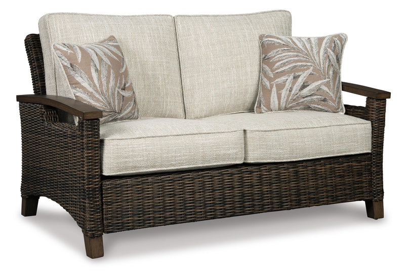 Outdoor patio set with Ashley Furniture Paradise Trail loveseat, lounge chairs, and fire pit table on a stylish outdoor patio.